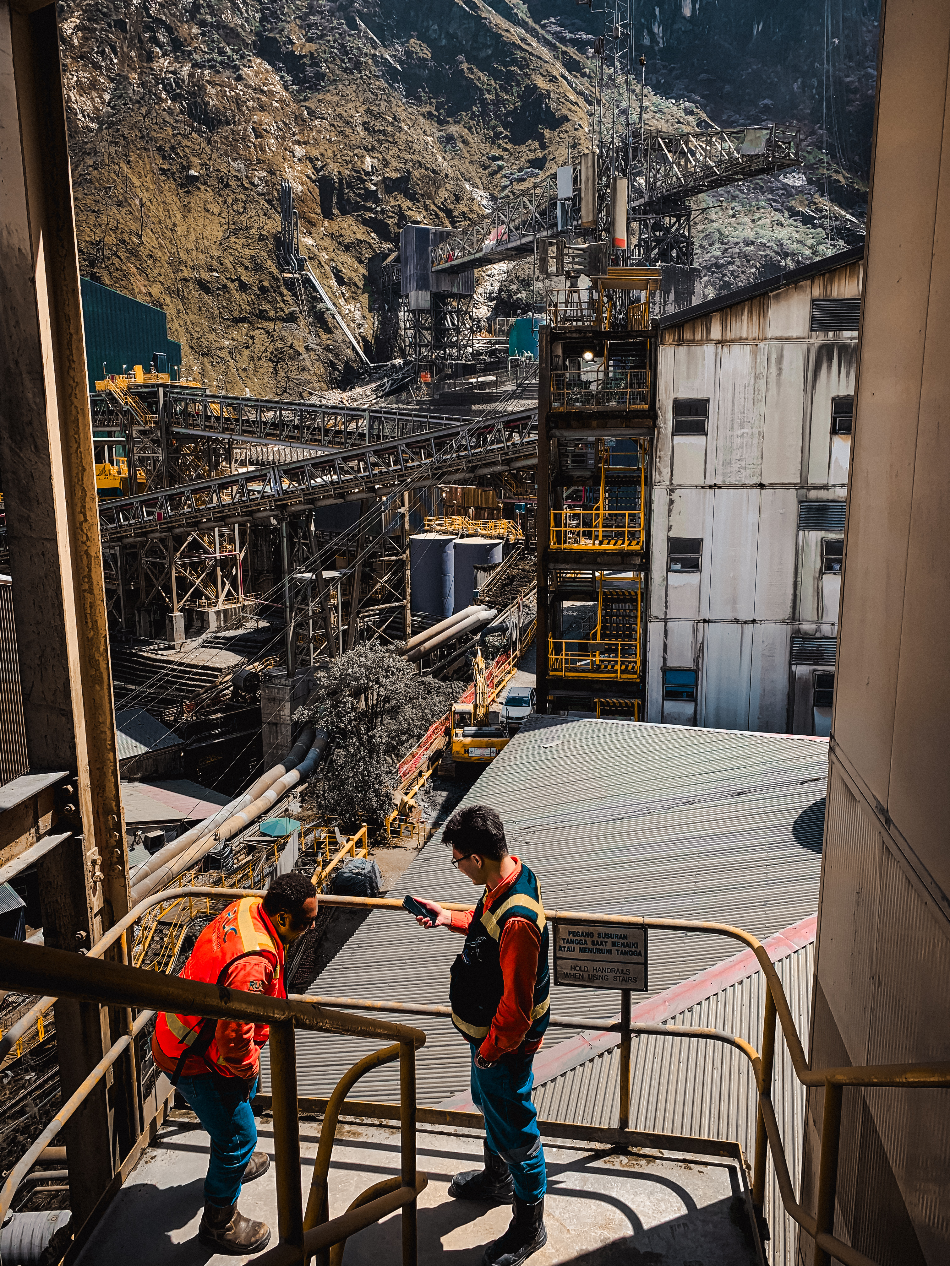 Two colleagues in high-visibility clothing at a mining facility